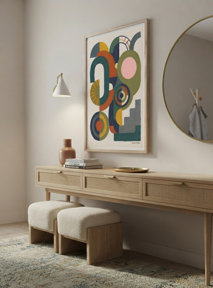A framed abstract Bauhaus Abstract Geometric Wall Poster inspired by aesthetic minimal block print art from Francis Phylae at Phylae Posters, hangs above a light wood console table with woven drawer fronts, two cream upholstered stools, a wall lamp, books, and a vase in a softly styled interior.