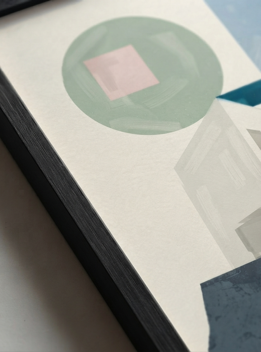 A close-up of a framed Minimalist Abstract House Print featuring geometric architecture and timeless Mid-Century Modern style by artist Francis Phylae, featuring a sage green circle, a pink square, and geometric shapes on a textured off-white background.