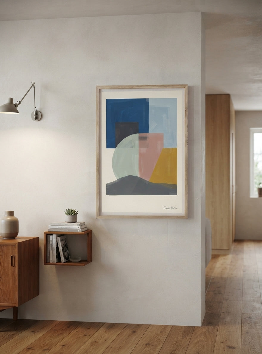 A framed Mid-Century Modern Geometric Landscape Art Print showcasing Organic Shapes Wall Art in warm muted colours by Francis Phylae at Phylae Posters hangs on a light gray wall in a modern interior setting with a wooden floor, wall sconce, and wooden shelving.