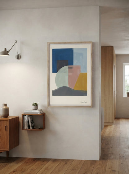 A framed Mid-Century Modern Geometric Landscape Art Print showcasing Organic Shapes Wall Art in warm muted colours by Francis Phylae at Phylae Posters hangs on a light gray wall in a modern interior setting with a wooden floor, wall sconce, and wooden shelving.